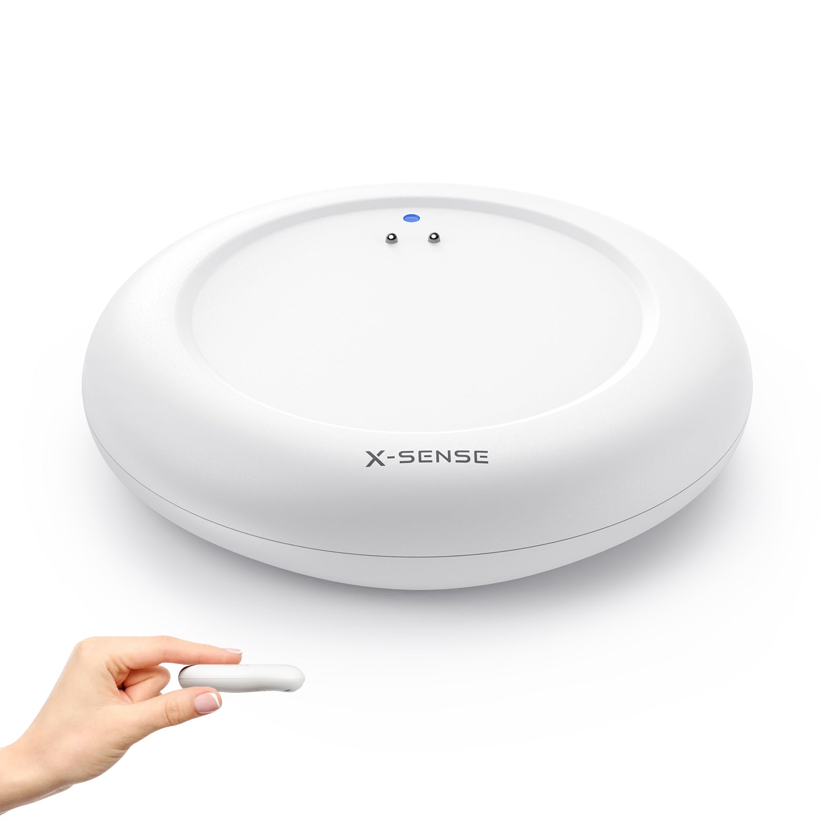 Vor einem weißen Hintergrund ist in der Mitte ein X-Sense SWS0A Wassersensor platziert, in der unteren linken Ecke hält eine Person das Gerät mit zwei Fingern.